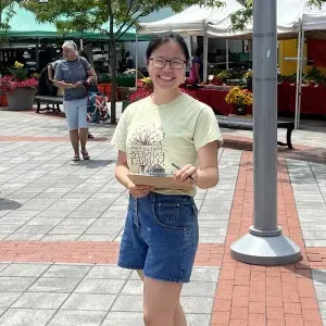 Erica Li at the farmer's market holding a clipboard.